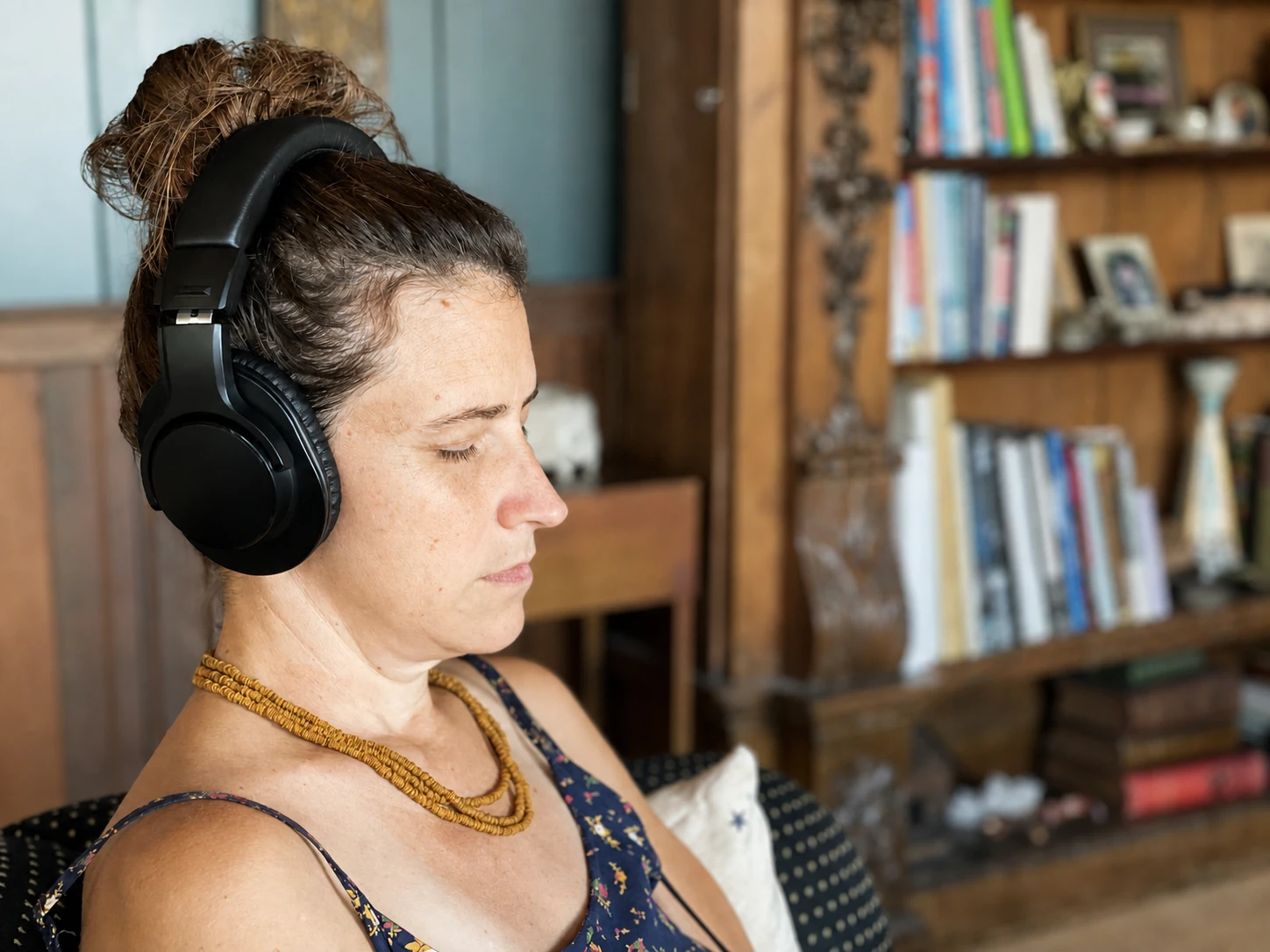 Lisa listening through headphones in a quiet room.